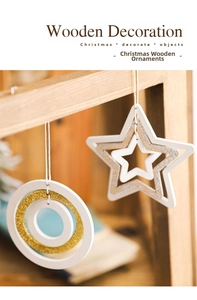 Close-up of white wooden star and ring ornaments with gold and silver glitter details
