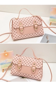 Détail du sac à bandoulière rose avec motifs géométriques et boucles métalliques