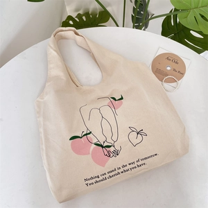 Detailed view of canvas tote bag featuring peach print and inspirational quotes