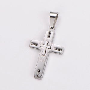 Detailed close-up of a silver stainless steel cross pendant with Greek key engravings