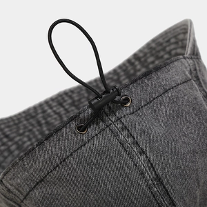 Detail of adjustable elastic drawstring and metal eyelet on vintage denim sun hat