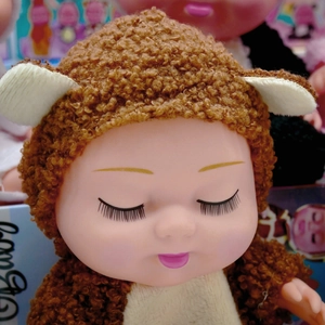 Close-up of an 8-inch sleeping BJD doll in a brown plush romper with cute white ears