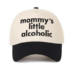 Close-up of black embroidery mommy's little alcoholic text on beige and black baseball cap