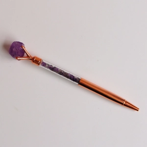Detail view of rose gold crystal pen with purple stones and raw amethyst top accent