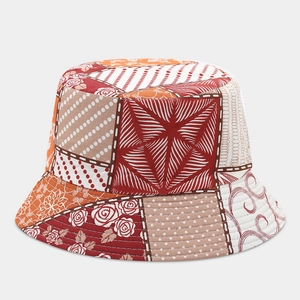 Dettaglio di un cappello da pescatore vintage con motivi floreali rossi e stampe geometriche