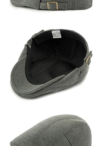 Detail of grey knitted cotton beret showing adjustable metal buckle and 100% cotton inner label