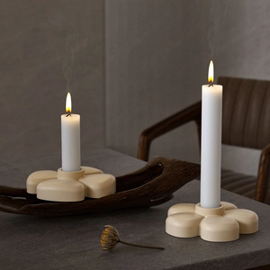 Clover petal resin candle holder with pillar candles on a dark stone surface
