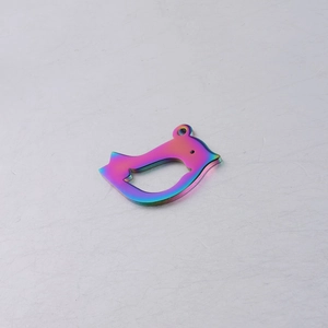 Detail shot of a rainbow-colored bird-shaped metal pendant with a high-gloss mirror finish