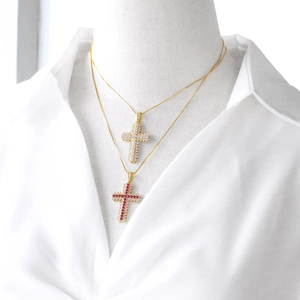 Collier avec pendentif croix plaqué or et zircons colorés sur un mannequin blanc