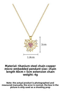 Macro detail of gold heart spider web pendant with pink gem and titanium steel chain