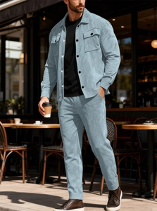 Detail of light blue corduroy shirt jacket with double chest pockets and matching pants