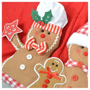 Detailed close-up of handmade gingerbread man plush ornaments on a red fabric background
