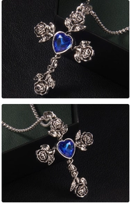 Detail of rose cross necklace with heart blue sapphire and vintage floral engraving