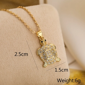Macro detail of a gold-plated turtle pendant with white zircons and dimensions 2.5x1.5cm