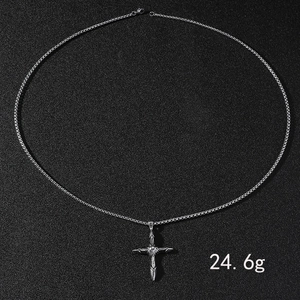 Gros plan d'un collier en acier inoxydable argenté avec pendentif croix pesant 24,6g au total