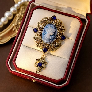 Detailed view of vintage relief brooch with blue cameo and gold setting in red velvet box