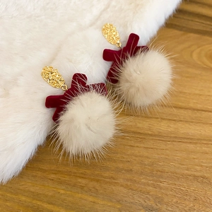 Close-up of heart studs with wine red fur pom poms and gold hammered metal accents