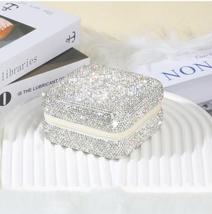 Close-up of square zipper jewelry box covered in sparkling silver rhinestones
