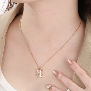 Close-up of geometric bear pendant necklace with purple and white enamel details