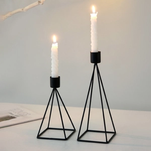 Set of two minimalist black iron geometric candle holders with elegant white spiral candles