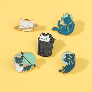 Close-up of five colorful enamel space cat pins including astronaut and planet designs