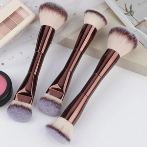 Detailed view of rose gold dual-ended makeup brushes for foundation and powder