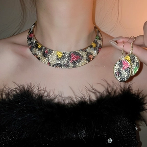 Detail of luxury leopard print jewelry set with rhinestones worn by a model