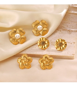 Detailed view of 18K gold plated floral earrings with pearls on silk and stone texture