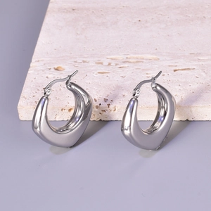 Polished silver stainless steel U-shaped hoop earrings on a neutral stone background