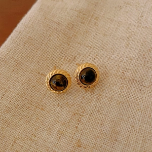Close-up of retro Maillard style gold stud earrings with round tiger eye stone inlay