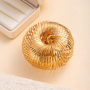 Minimalist golden spiral spring bangle in a high-gloss finish with elegant jewelry box