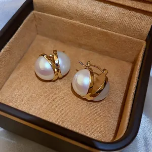 Elegant double pearl hoop earrings with gold-tone cross setting in a brown velvet box