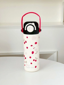 Detail of cute strawberry print on portable stainless steel thermos with handle