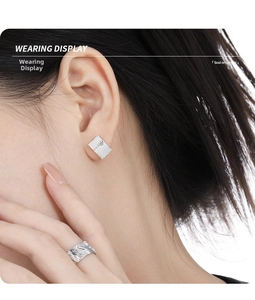 Wearing display of brushed silver studs and textured open ring with zircon detail