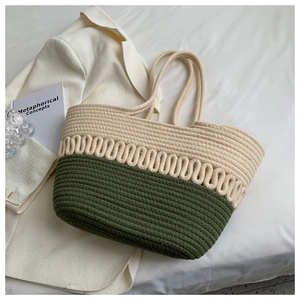 Detail of handwoven tote bag in cream and olive green beside a white blazer and book