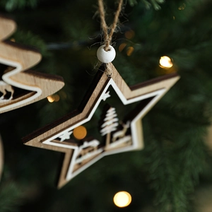Wooden star Christmas ornament with reindeer carving hanging on a festive tree