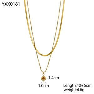 Detail of golden double-layer sun pendant necklace with snake chain and bead chain