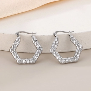 Détails de la finition martelée sur les boucles d'oreilles géométriques en acier argenté