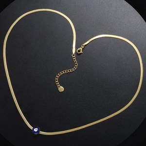 Golden snake chain necklace with blue evil eye pendant arranged in a heart shape