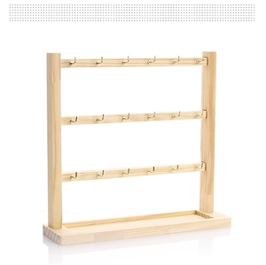Detail of wooden earring holder with 18 gold metal hooks and storage base groove