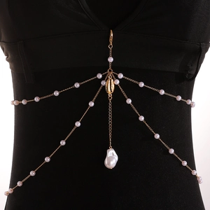 Detail of gold pearl body chain featuring shell and starfish pendants on a black vest