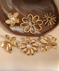 Detail of gold floral brooches with pearl accents and hollow geometric designs