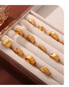 Collection of gold-plated geometric rings in a velvet box showing various textures