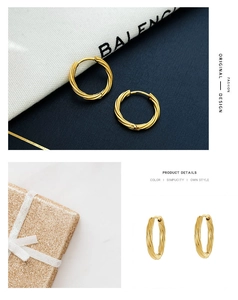 Detailed view of gold twisted hoop earrings featuring spiral texture on luxury box