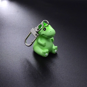 Detail shot of a cute green resin dinosaur keychain with matte finish and silver metal ring