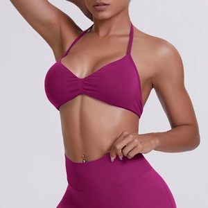 Close-up of seamless magenta gym set featuring halter sports bra with center ruching