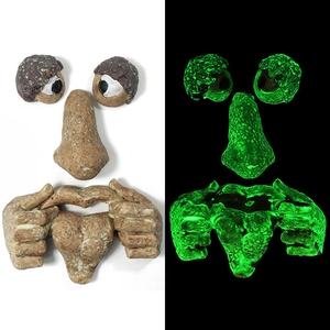 Luminous tree face garden decoration showing glowing green eyes and mouth in the dark