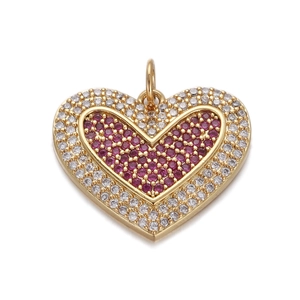 Macro shot of heart pendant with red center stone and clear crystals in gold plating