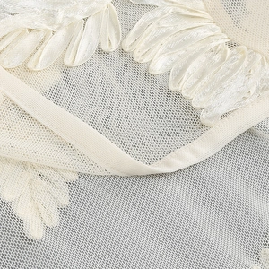 Close-up of white tube fisheye dress showing delicate mesh and ribbon embroidery detail