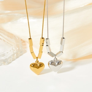 Elegant gold and silver heart pendant necklaces on silk fabric with glass decor